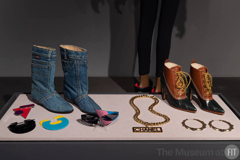 Matake denim boots, 1985-1986, asymmetric plastic sunglasses, circa 1986, Bill Blass black Lucite cuff, 1982, Tess Designs blue and yellow Lucite cuffs, fall 1982 and silver and Lucite brooch, 1985, Manolo Blahnik booties, circa 1994, Chanel “dookie” chain, fall 1991, “door-knocker” earrings, 2020