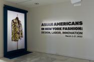 Installation view of Asian Americans in New York Fashion: Design, Labor, Innovation exhibition title featuring a projection of a Shail Upadhya design.