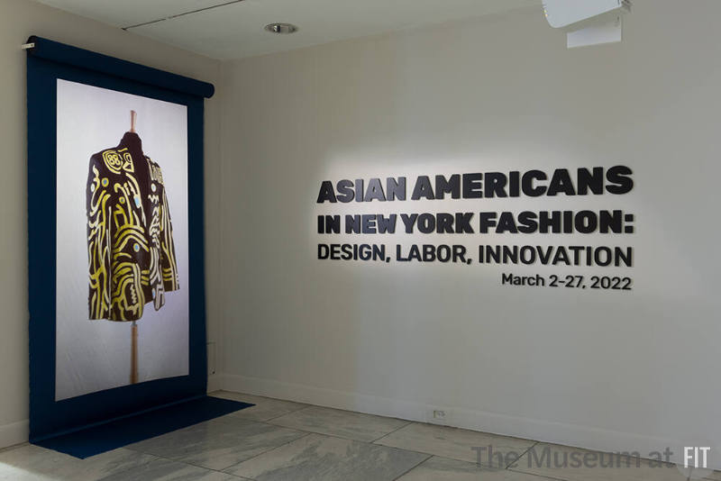 Installation view of Asian Americans in New York Fashion: Design, Labor, Innovation exhibition title featuring a projection of a Shail Upadhya design.