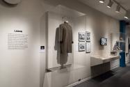 Installation view of Labor section featuring a jacket by Yeohlee Teng and additional ephemera.