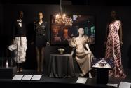 Food & Fashion Left to right: Judith Leiber Couture, Ice Champagne Bottle Bubbly minaudière, Fall 2021. Lent by Judith Leiber Couture; 2015.64.1 (waiter ensemble), 2020.6.1 (black suit), 88.105.10 (beige dress), 2009.19.1 (white printed dress)
