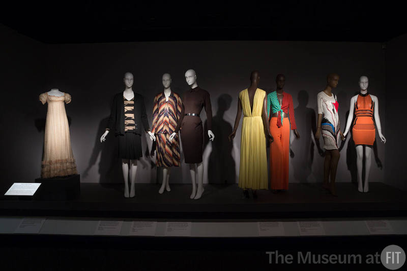 Fabric_17 Left to right P89.40.6 (dress), 80.13.19 (ensemble), 92.42.8 (multicolor  ensemble), 2003.16.3 (dress), 2015.77.1 (yellow gown), 2016.32.5 (top and pants), 2010.72.1 (knit dress), 2015.17.1 (dress)