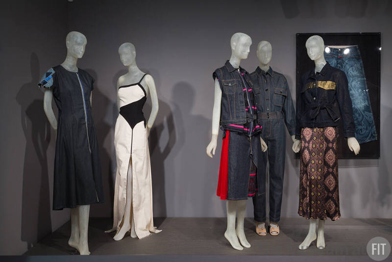 Denim_24 Left to right 2015.41.2 (dress), 2010.7.1 (black and white dress), 2015.37.2 (vest ensemble), 2015.39.1 (ensemble), 2015.43.1 (ensemble with gold), 2015.63.2 (jeans wall)