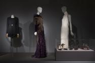 Fashion A-Z (II)_30 Left to right 2001.63.8 (suit), 2012.1.1 (gown), 2004.59.2 ( dress), 2005.76.1, 2010.20.1, 2010.65.4 (shoes case)