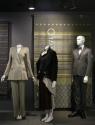 Tailor_18 Left to right  2005.90.5 (suit),  2003.60.2 (skirt ensemble), 2005.25.1 (textile wall), 2006.16.1 (grey suit)