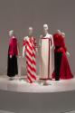YSL+Halston_39 Left to right 82.99.1 (pink and black gown), 80.128.10 (red white stripe dress), 2014.38.2 (ivory evening dress), 2007.56.16 (ruffle top and black skirt),  91.185.2 (red strapless gown)