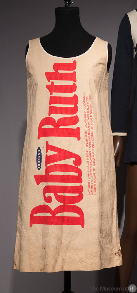 Beige knee length sleeveless dress with vertical Baby Ruth logo across front