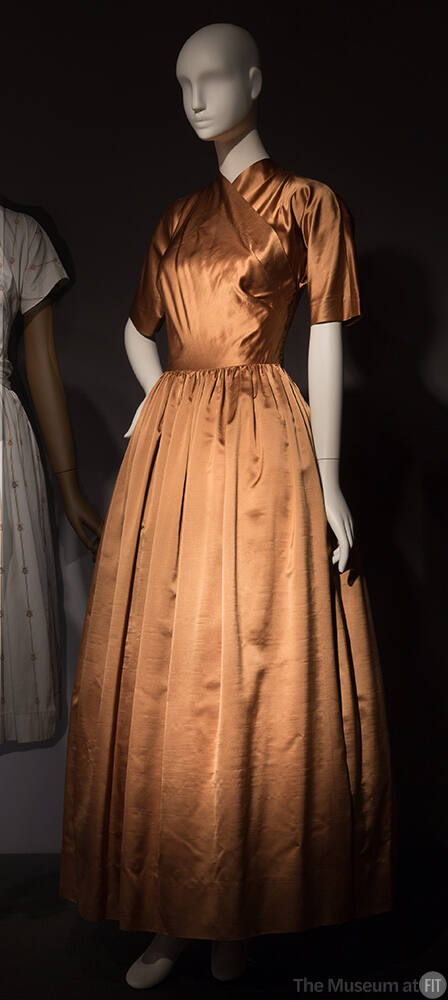Gold dress with cross over bodice creating high v-neck, elbow length sleeves and full floor len…