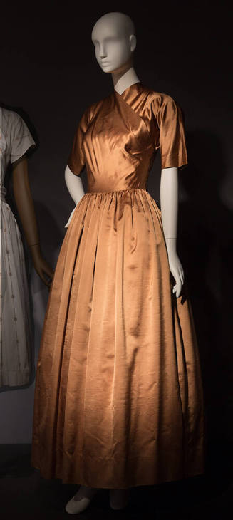 Gold dress with cross over bodice creating high v-neck, elbow length sleeves and full floor len…