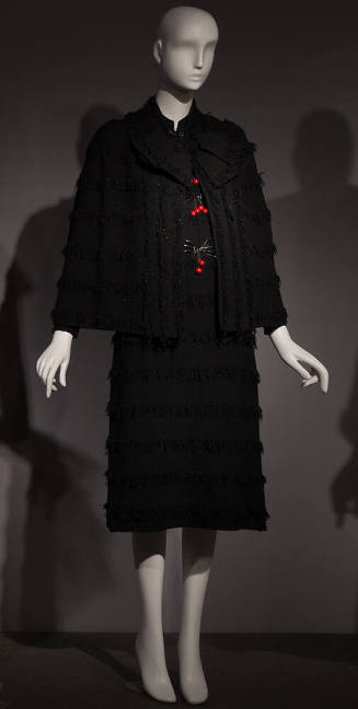 Black long sleeve cape and knee length sheath dress set with horizontal stripes of fringe, larg…