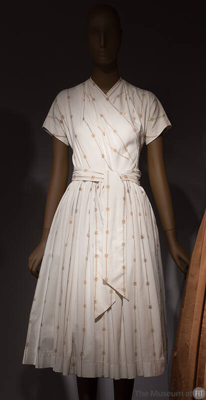 White ribbed popover short sleeve  dress with fine beige and brown stripes and small crest moti…
