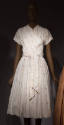 White ribbed popover short sleeve  dress with fine beige and brown stripes and small crest moti…