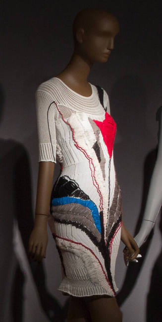 White knit above-the-knee dress with red, blue black and grey abstract stitching, 3/4 sleeves a…