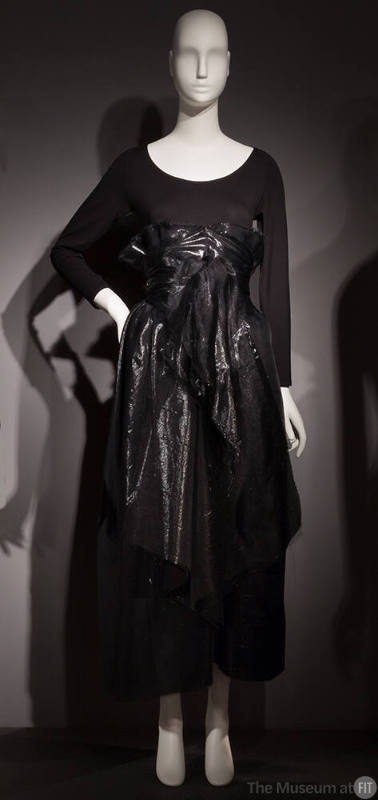Black long sleeve body suit with black shiny high-waisted ankle-length wrap skirt 