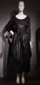 Black long sleeve body suit with black shiny high-waisted ankle-length wrap skirt 