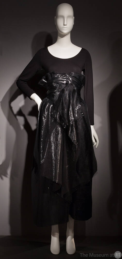 Black long sleeve body suit with black shiny high-waisted ankle-length wrap skirt 