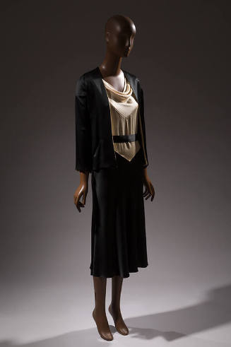 Black jacket over dress with white cowl neck bodice and black skirt 