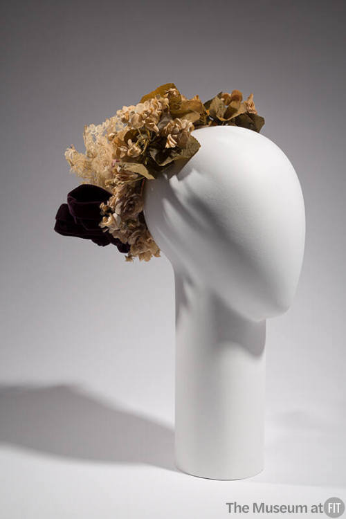 Small hat covered in purple silk violets and green leaves with purple bow and cream lace
