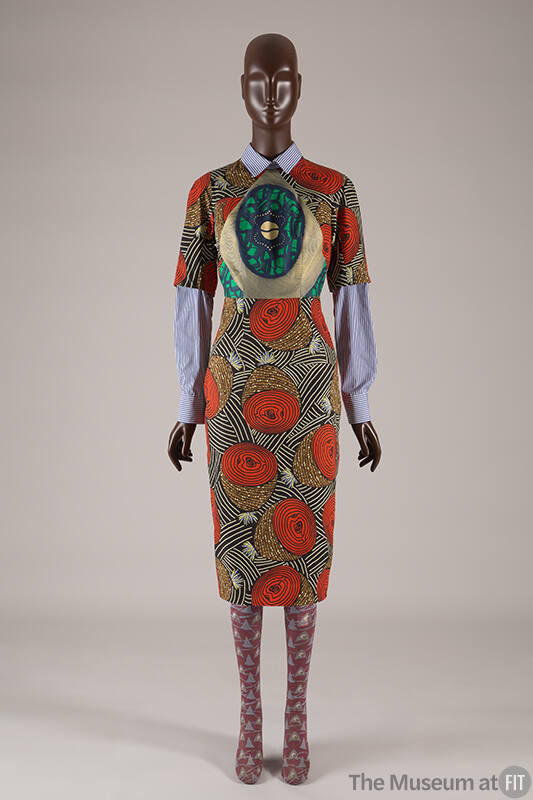 ¾ sleeve knee length shirt dress with orange stylized geometric motifs and blue, green and gold…