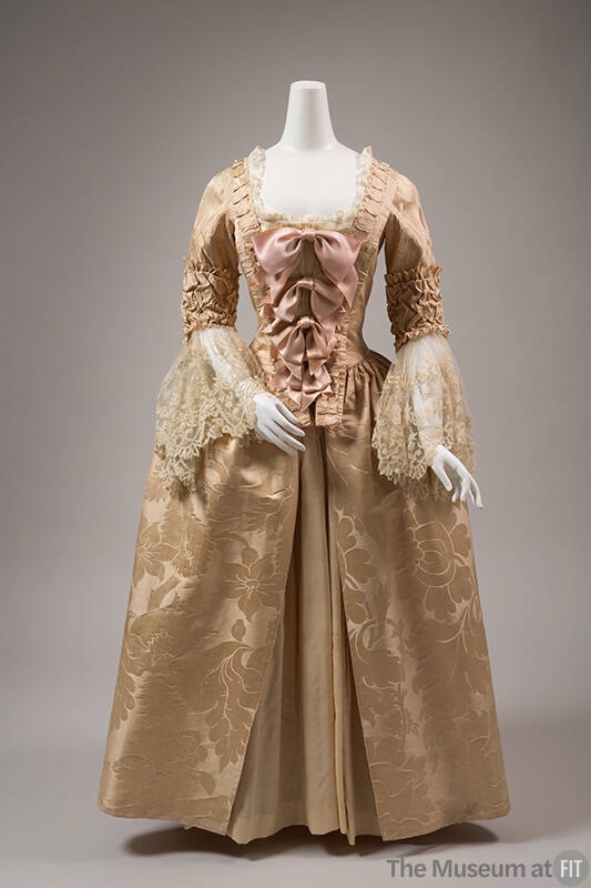 Pale pink silk floral damask dress with white lace sleeve panels, pink bows descending in size …