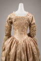 Back view of pale pink silk dress showing floral damask, ruching around elbows of sleeves and f…