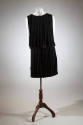 Black knee-length evening dress with two tiers of fringe at neck and waist