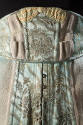Detail view of top of blue/green girdle showing gold metallic brocaded floral design with ribbo…