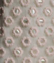 Detail view of white mini dress showing pink satin overlay of daisies and paillette centers