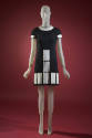 Black mini dress with white vinyl collar, short sleeves and white rectangles at front and hem