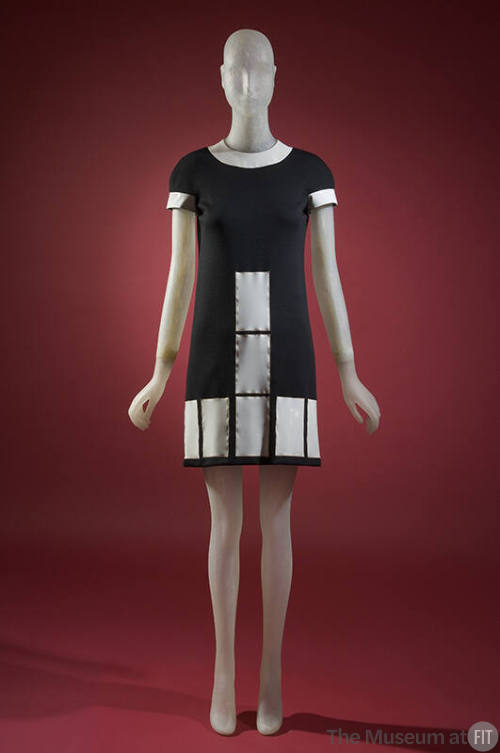Black mini dress with white vinyl collar, short sleeves and white rectangles at front and hem