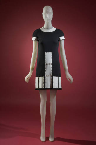 Black mini dress with white vinyl collar, short sleeves and white rectangles at front and hem