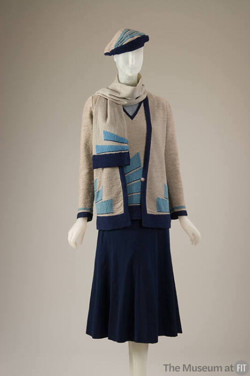Knit ensemble of grey cardigan sweater with turquoise and navy blue wedge motifs, matching V-ne…