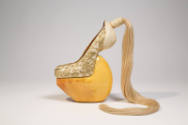 gold metallic lace over beige heel-less shoes with high wood platform and blond hair ponytail a…
