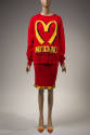 red sweater with yellow "Moschino Over 20 Billion Served" print and large yellow "M" and machin…
