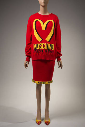 red sweater with yellow "Moschino Over 20 Billion Served" print and large yellow "M" and machin…
