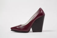 Side view of single burgundy pump showing black high wedge heel