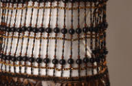 Detail view of brown beaded evening mini dress showing openwork midriff of horizontal rows of b…