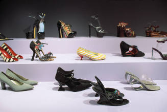 Shoes: A Lexicon of Style exhibition installation view of multiple pairs of shoes on a platform
