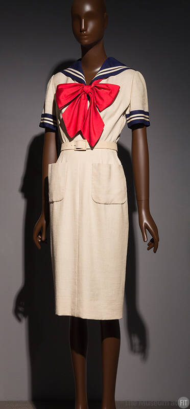 White sailor style knee length sheath dress with navy blue sailor collar, short sleeves, patch …