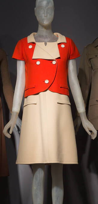 Red double breasted jacket with white lapels over white knee length dress