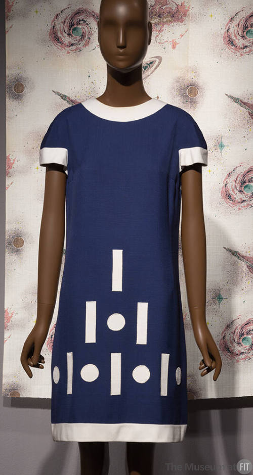 Blue dress with white trim; dot and dash pattern at lower front