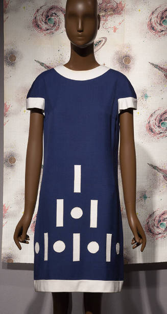 Blue dress with white trim; dot and dash pattern at lower front