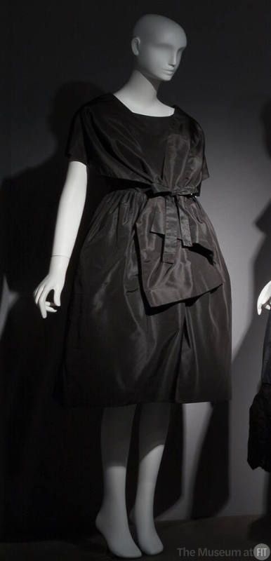 Black cocktail dress with fitted bodice, back wrap styling, dome skirt, and bow at waist