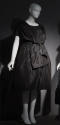 Black cocktail dress with fitted bodice, back wrap styling, dome skirt, and bow at waist