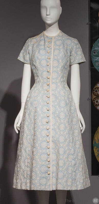 Light blue below-the-knee dress with white floral design, short sleeves and white crocheted but…
