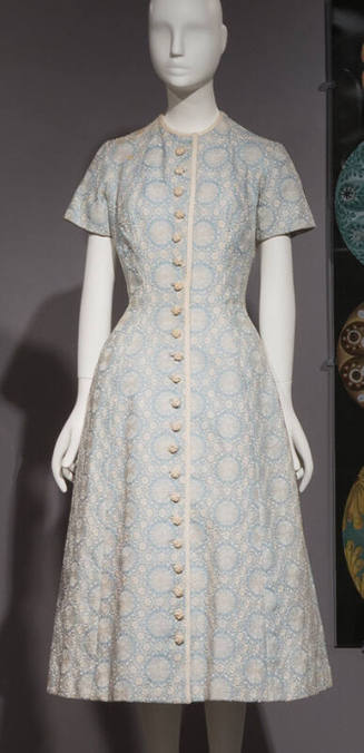 Light blue below-the-knee dress with white floral design, short sleeves and white crocheted but…