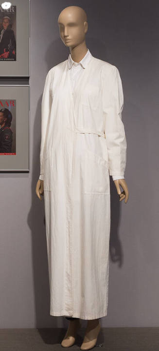 White long sleeve floor length lab coat with button front, three patch pockets and wrap around …