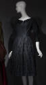 Black silk boat neck dress with 3/4 sleeves, multiple fringe tassels on full to-the-knee skirt