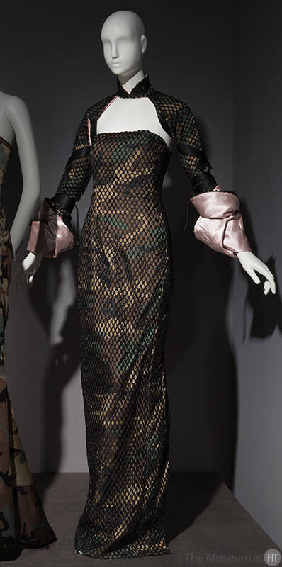 Floor length green camoflauge strapless dress and capelet sleeves; black large net lace overlay