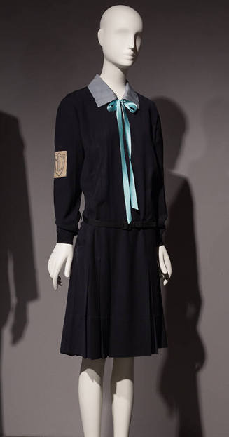 Navy blue uniform dress with long sleeves, light blue collar with aqua blue ribbon bow tied at …